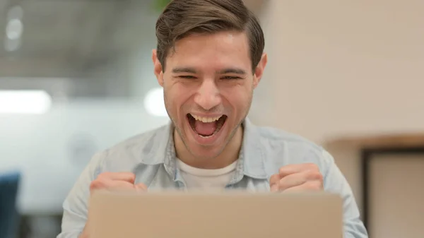 Nahaufnahme eines jungen Mannes, der Erfolg am Laptop feiert — Stockfoto