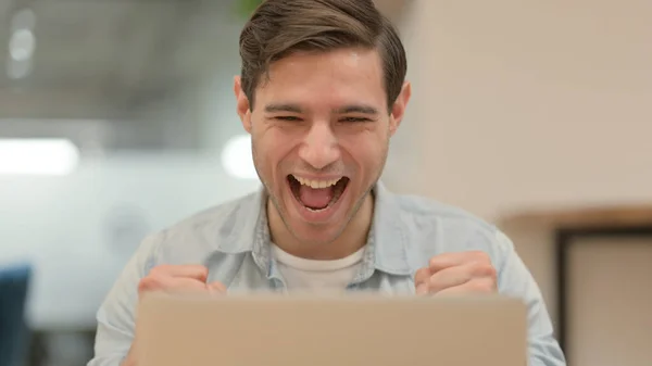 Primo piano del giovane uomo che celebra il successo sul computer portatile — Foto Stock