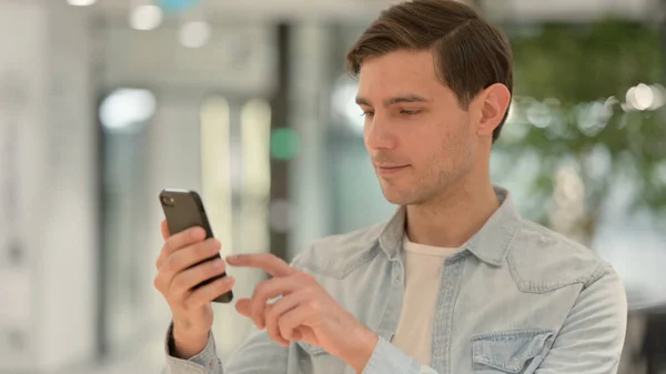 Portrét mladého muže pomocí chytrého telefonu — Stock fotografie