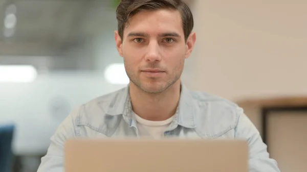 Közelkép a fiatal férfi laptoppal Nézi a kamera — Stock Fotó