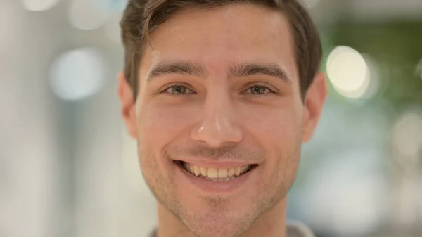 Close-up van de jonge man glimlachend bij de camera — Stockfoto