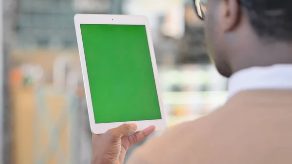 Uomo africano utilizzando tablet con schermo verde — Foto Stock