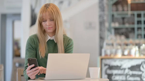 Mujer Trabajando en Smartphone y Laptop en Café en Café — Foto de Stock