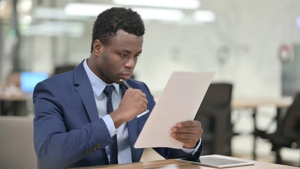 Afrikansk affärsman Läsa dokument i Office — Stockfoto