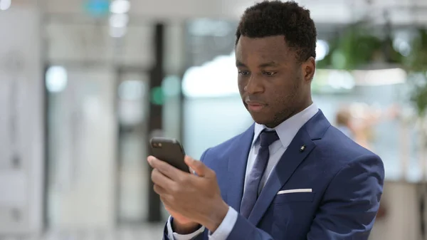 Homme d'affaires africain utilisant Smartphone dans le bureau — Photo