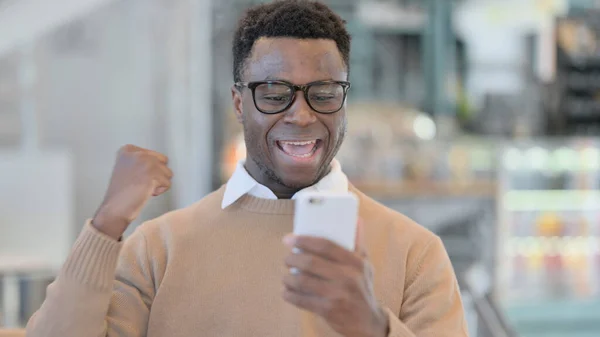 Homem Africano comemorando no Smartphone — Fotografia de Stock