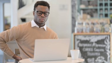 Dizüstü bilgisayar kullanırken Sırt Ağrısı Olan Afrikalı Adam 