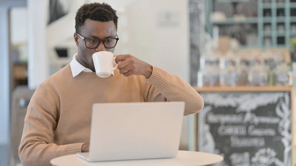 카페에서 노트북을 사용하면서 커피를 마시는 아프리카 남자 — 스톡 사진