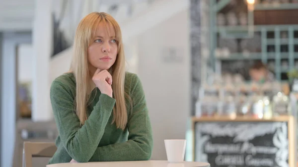 Vrouw zit in Cafe en denken — Stockfoto