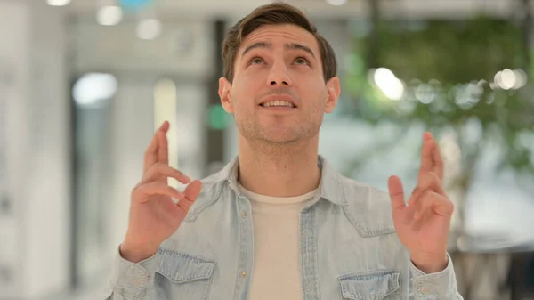 Retrato de un joven rezando, dedos cruzados — Foto de Stock