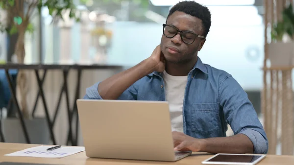 African Man mając ból szyi podczas pisania na laptopie — Zdjęcie stockowe