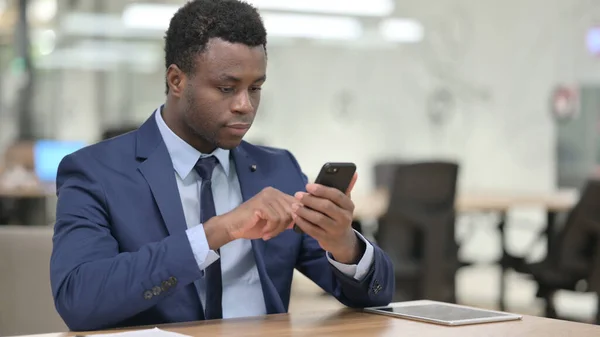 Homme d'affaires africain utilisant Smartphone dans le bureau — Photo