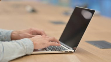 Dizüstü bilgisayarda yazan genç adama yaklaş. 