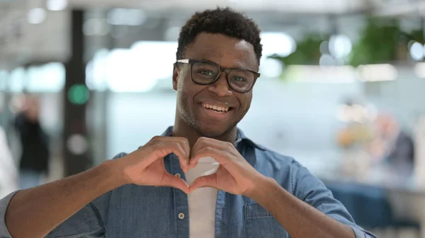 Porträtt av afrikansk man visar hjärtform av händer — Stockfoto