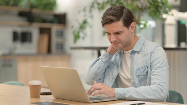 Junger Mann mit Laptop hat Nackenschmerzen — Stockfoto