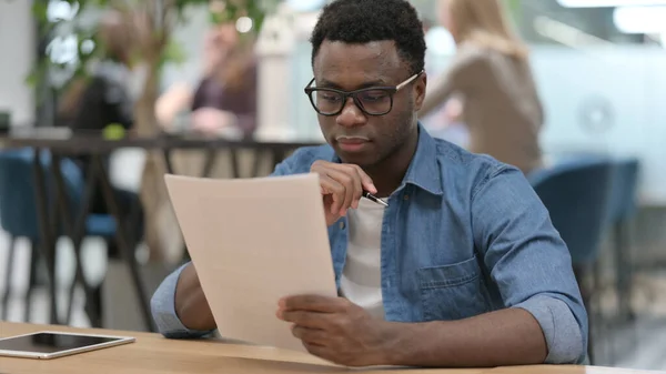 Afrikansk man Läsa dokument i moderna kontor — Stockfoto