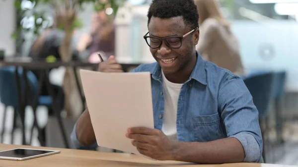 Afrikaner feiert beim Lesen von Dokumenten — Stockfoto