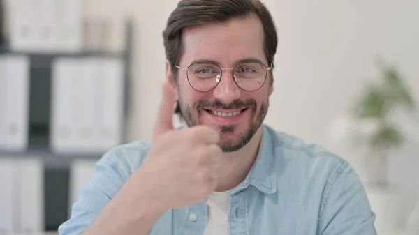 Retrato de un joven mostrando el signo de pulgares hacia arriba — Foto de Stock