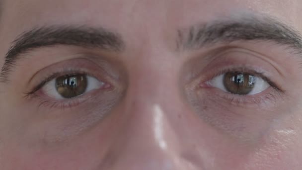 Primer plano de los ojos parpadeantes de un hombre joven — Vídeos de Stock