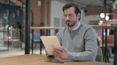 Ofiste otururken Tablet kullanan genç adam