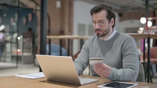 Молодий чоловік робить помилку онлайн платежів на ноутбуці в офісі — стокове відео