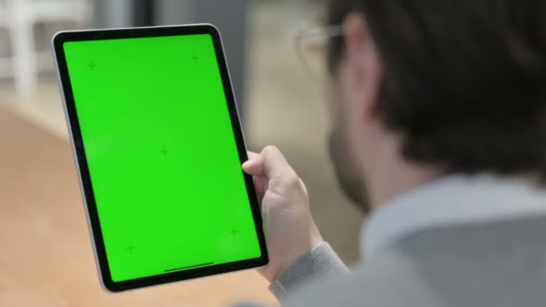 Человек с помощью планшета с зеленым хроматическим экраном — стоковое видео