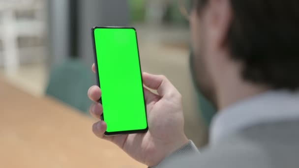Mann blickt auf Smartphone mit grünem Chroma-Bildschirm — Stockvideo