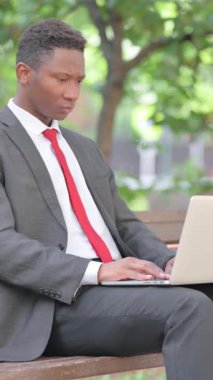 Afrikalı Adam Çevrimiçi Alışverişin Tadını Çıkartıyor Laptop ile Açık havada