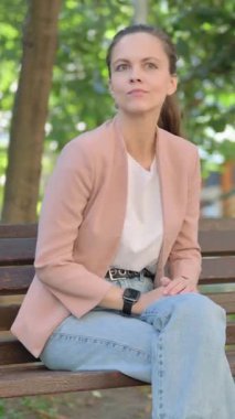 Genç Kadın Park 'ta otururken Akıllı Saat Kullanıyor