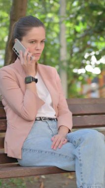 Kızgınlıkla telefonda konuşan sıradan genç bir kadınla dövüşmek.