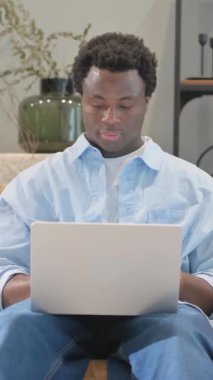 Evde dizüstü bilgisayar kullanan Öksüren Hasta Afrikalı Adam