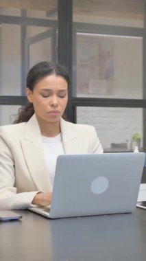 Ofiste dizüstü bilgisayarla çalışırken Afrikalı İş Kadını Kameraya Bakıyor