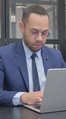 Dikey, Takım Elbiseli Adam Dizüstü bilgisayarda çalışırken kamerayı işaret ediyor