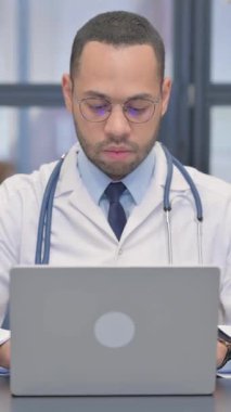 Dikey, Gülümseyen Karışık Yarış Doktoru Laptop üzerinde çalışıyor