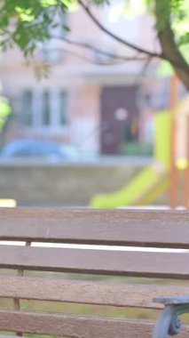 Dikey video, Gelişigüzel Afrikalı Adam Bench Açık Hava 'da Oturuyor