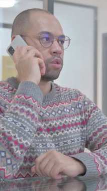 Genç İspanyol adam telefonda konuşuyor, dikey video.