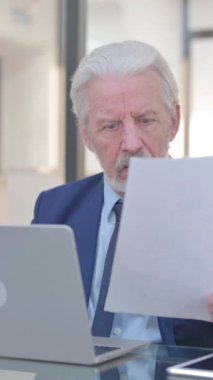 Eski İşadamı Kontrat Okurken Üzülüyor ve Dizüstü bilgisayar kullanıyor, dikey video