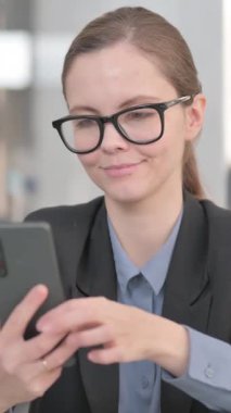 Genç İş kadınının portresi Telefonda Başarı Kutlaması, dikey video