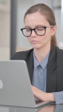 Ofisteyken kameraya bakan iş kadını, dikey video