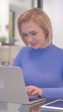 Ofiste Dizüstü bilgisayar üzerinde çalışırken Başparmakları havada genç kadın, dikey video