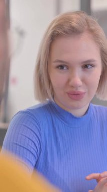 Yaratıcı Takım Arkadaşı ile Sarışın Kadın Konuşuyor 'un yakın çekimi, dikey video