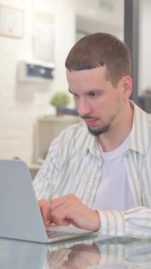 Yaratıcı Genç Adam Dizüstü bilgisayarda Başarı İçin Heyecanlı, dikey video