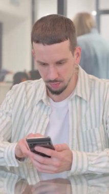 Ofiste İnternet 'e göz atan yaratıcı genç adam, dikey video