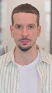 Kamerayı gösteren yaratıcı genç adamın portresi, dikey video