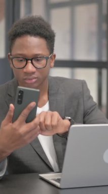 Dikey, Afro-Amerikan Adam Laptop ile Telefon Kullanıyor