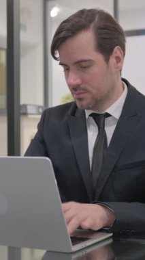 Orta yaşlı İşadamı Laptop 'ta çalışıyor, dikey video
