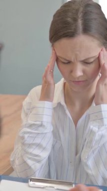 Olgun Danışman 'la otururken baş ağrısı çeken kadın, dikey video.