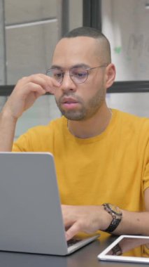 İspanyol adamın iş yerinde baş ağrısı var, dikey video.