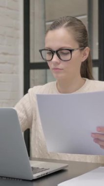 Belgeler ve Laptop üzerinde Çalışan Yaratıcı Kadın, dikey video