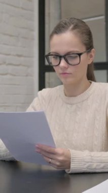 İş yerinde Belgeleri Okuyan Yaratıcı Kadın, dikey video